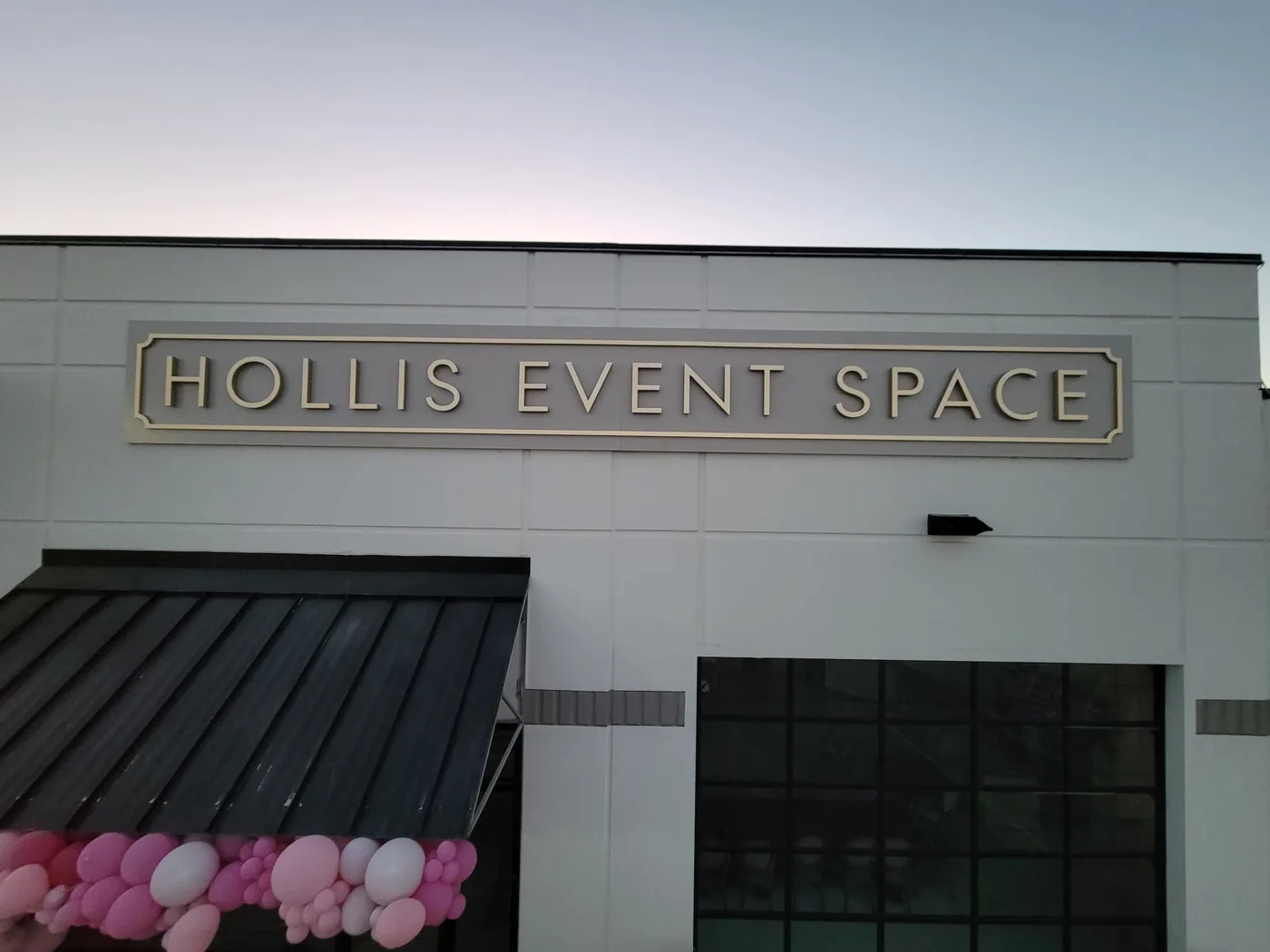 Elegant dimensional letter sign for Hollis Event Space on a white commercial building facade in Houston, Texas
