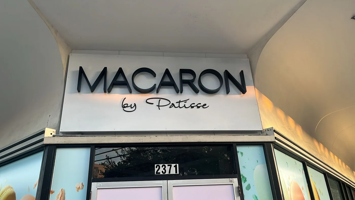 Dimensional letter sign for Macaron by Patisse dessert shop on a retail storefront fascia in Houston, Texas