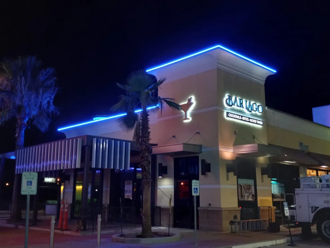 Illuminated storefront sign with neon accents for Bariago bar and restaurant in Houston, Texas, lit at night