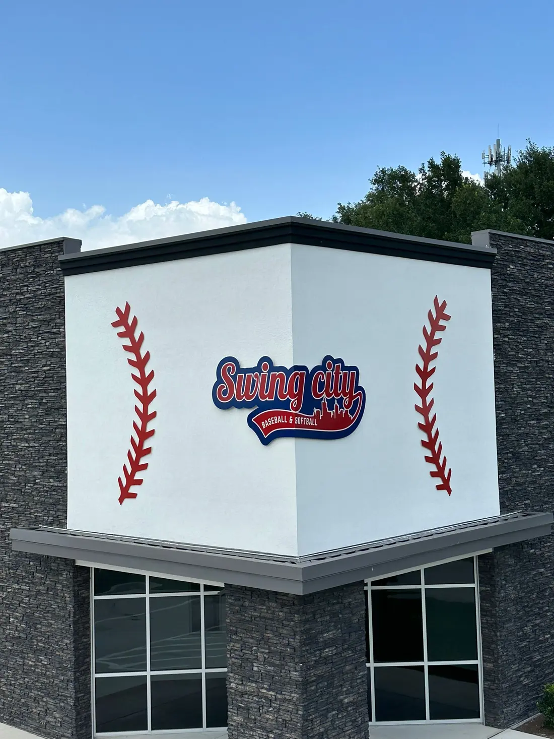 Custom dimensional logo sign for Swing City Baseball and Softball on a building corner in Houston, Texas