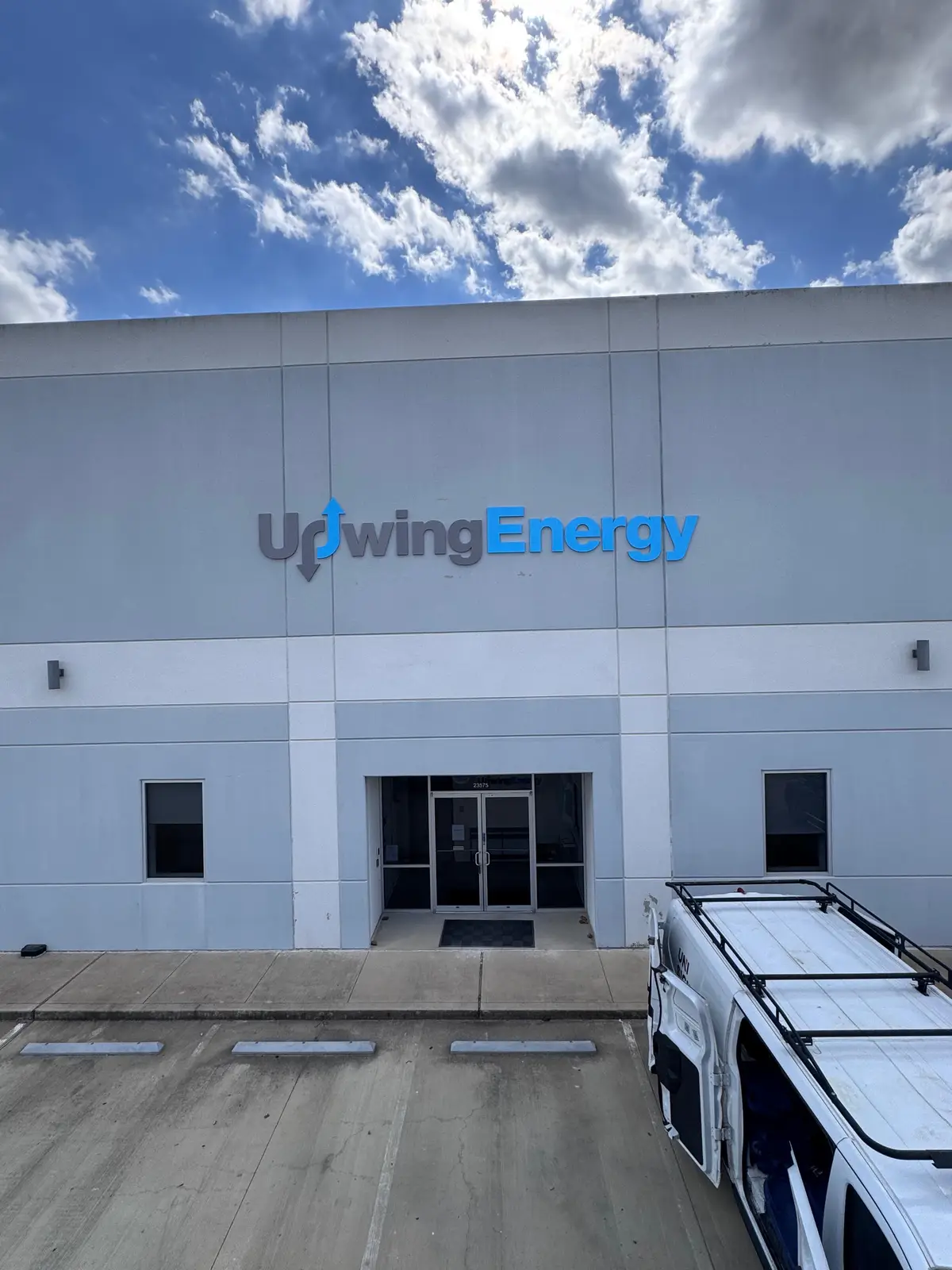 Large dimensional building identification sign for Upwing Energy on a commercial warehouse facade in Houston, Texas