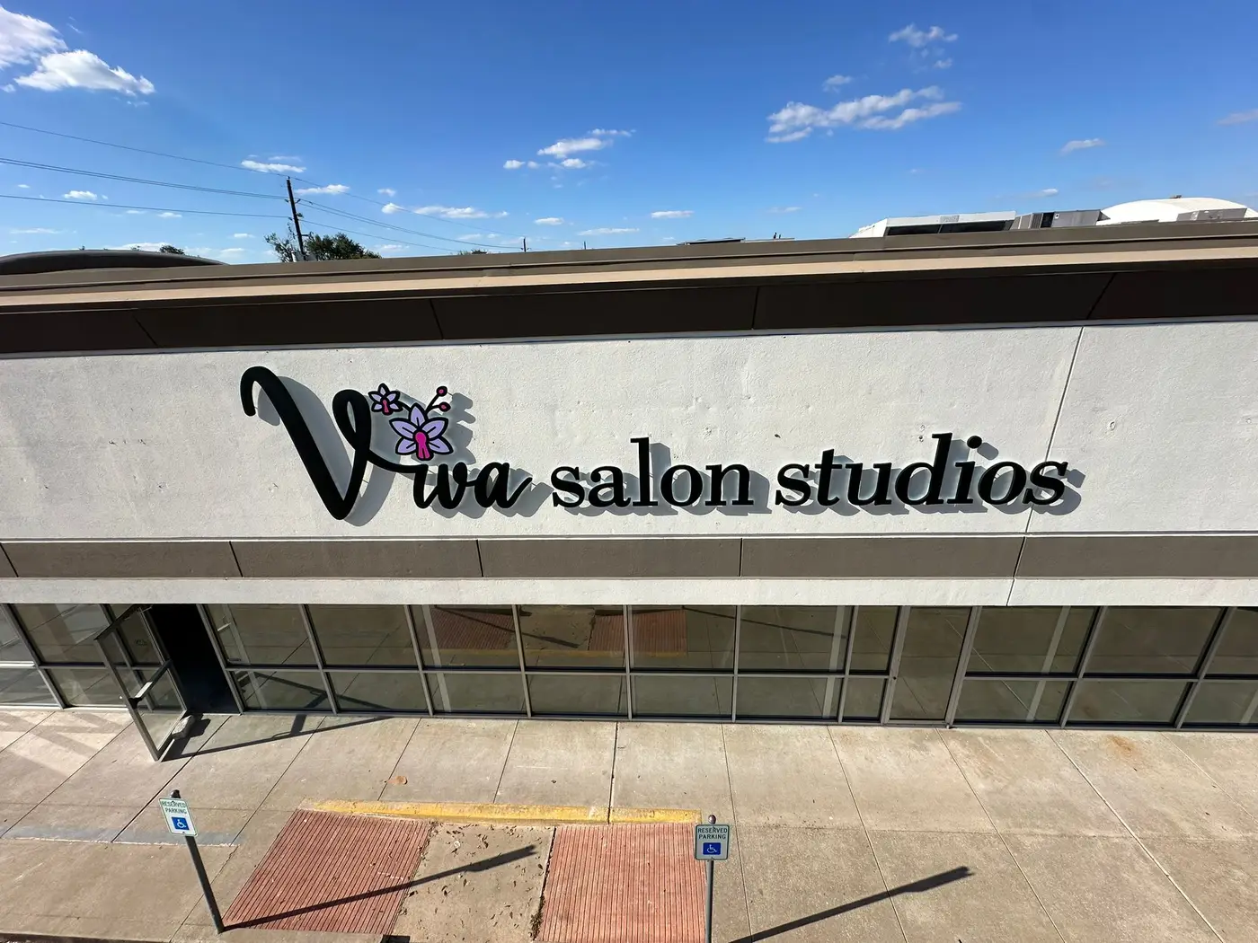 Dimensional letter storefront sign for Viva Salon Studios on a large commercial building facade in Houston, Texas